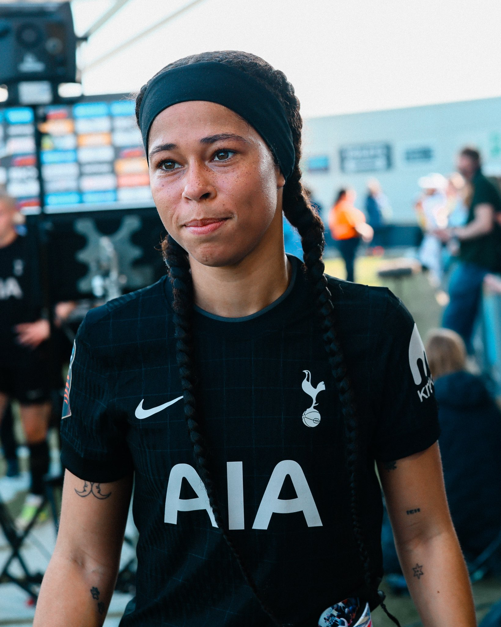 Lenna Gunning-Williams, with pigtail braids and a headband, smiles close-mouthed.
