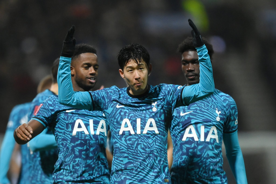 Son Heung-min throws his hands up in celebration, while Ryan Sessegnon and Yves Bissouma approach.