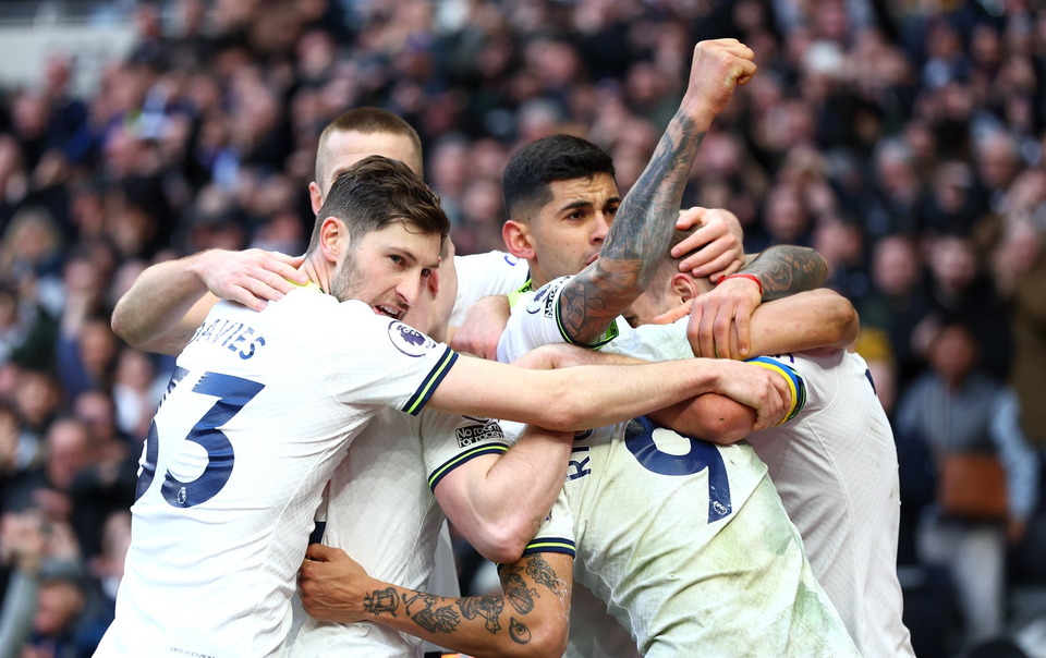 Several players from Spurs Men huddle together to celebrate a goal.