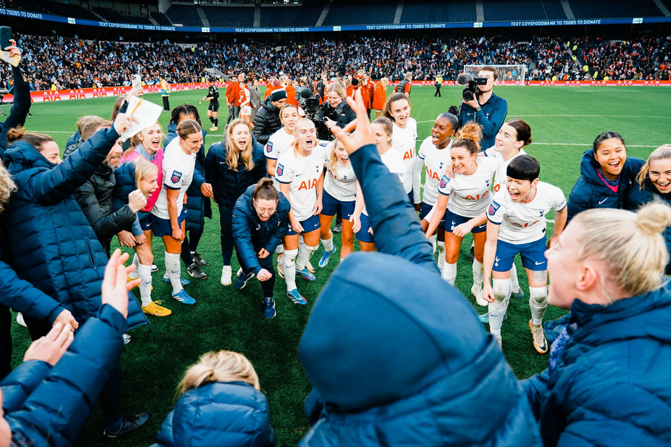 The entire Spurs Women team (players and staff) celebrate their first NLD win.