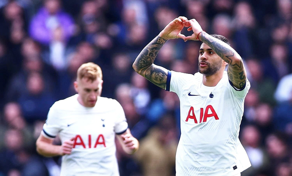 Cristian Romero makes a heart with his hands as Dejan Kulusevski jogs in the background.