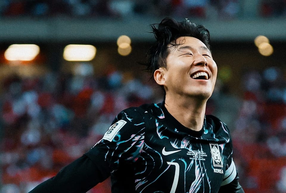 Son Heung-min smiles with closed eyes as he runs forward