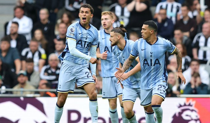 Brennan Johnson jumps to celebrate a forced own goal by Newcastle United, flanked by his teammates.