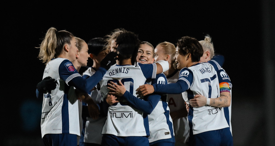 Araya Dennis is swarmed by her celebrating teammates after scoring her first Spurs goal.