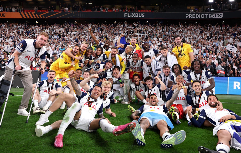 The entire squad poses in front of fans with the Europa League trophy and their medals.
