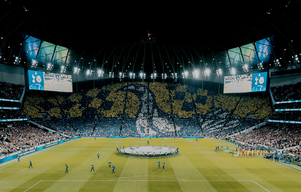 A yellow, navy, and white cockerel tifo in the south stand at Tottenham Hotspur Stadium