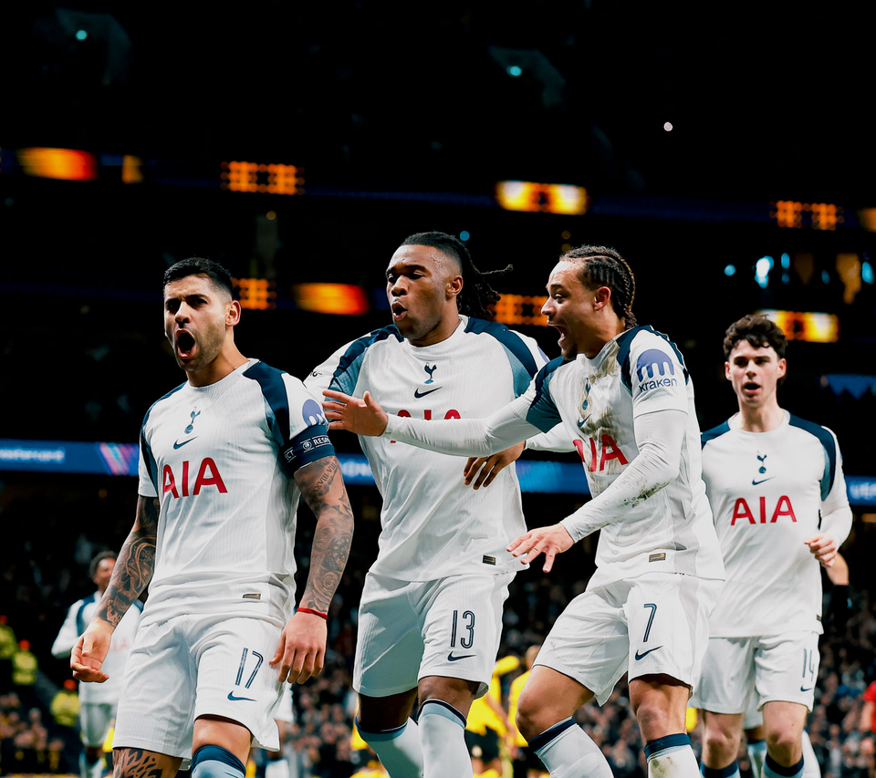 Cristian Romero roars, flanked by several teammates.